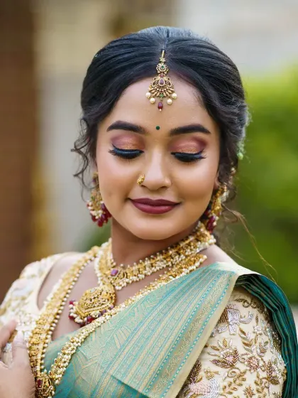 A classic South Indian bridal look with soft, shimmery eyes and traditional gold jewelry. This is a timeless look that is always in demand.