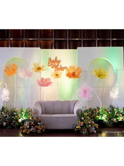 The main stage for a "Baby in Bloom" themed baby shower. We used a clean, modern backdrop with oversized paper flowers and soft, ambient lighting to create a beautiful focal point for photos and celebrations.