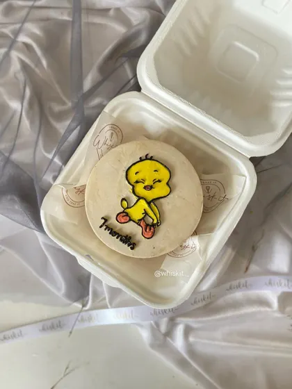 This bento cake features a hand-drawn Tweety Bird to celebrate a 7-month milestone. It's a nostalgic and cute design for a baby's monthly birthday.