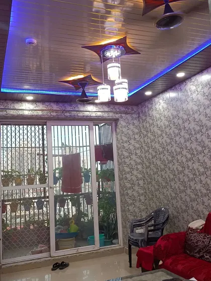 A view of the living room showing the new PVC ceiling with integrated lighting and fan fixtures.