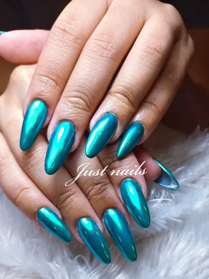 A mesmerizing metallic green chrome finish on long, almond-shaped nail extensions. This look is sleek, futuristic, and guaranteed to turn heads.