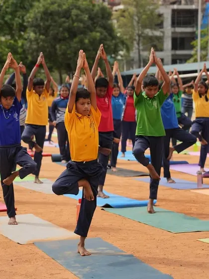 A group of boys holding a steady Vrikshasana (Tree Pose), finding their balance together.