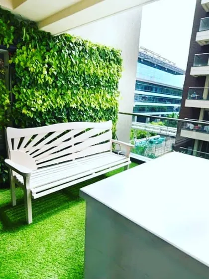 We transformed this compact city balcony into a private green oasis. The design features a full-coverage vertical garden that turns a bare wall into a living feature, complemented by low-maintenance artificial turf and a comfortable seating area, proving no space is too small for a natural escape.