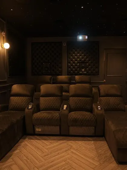 This shot highlights the custom seating, which includes recliners with extended chaise lounges for a truly relaxing viewing experience.