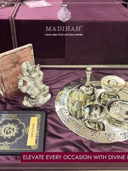 Elevate every occasion with divine luxury. My Pooja Auspicious Hamper includes a silver-plated thali set, a Ganesha idol, and a Geeta Saar, all presented in a beautiful velvet box.