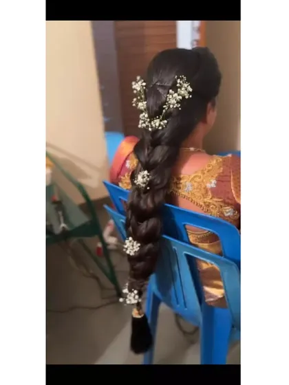 A long, flowing braid decorated with sprigs of baby's breath for a delicate and romantic feel.