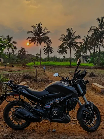 A black Dominar 400 parked in a rural landscape at sunset. A perfect end to a day of exploration.