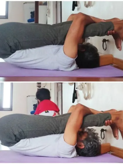 This is Karnapidasana, or Ear Pressure Pose, a deep forward fold that brings a sense of introspection and calm. The image captures the idea that happiness is found in the present moment of practice.