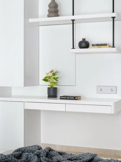 The minimalist workspace in the lavender bedroom, featuring a floating desk and open shelving.