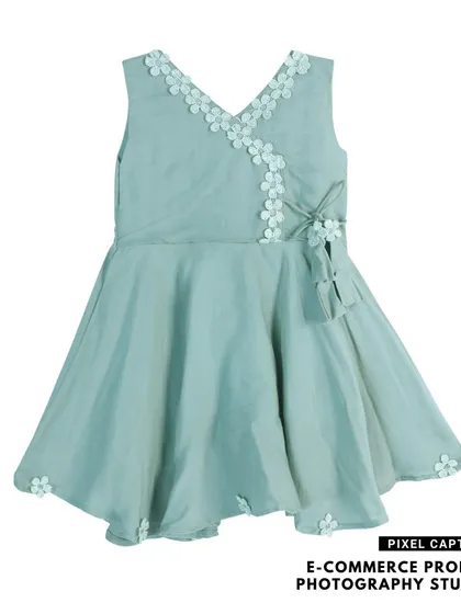 A beautiful flat lay of a light green, V-neck baby frock with floral details, ready for your online boutique.