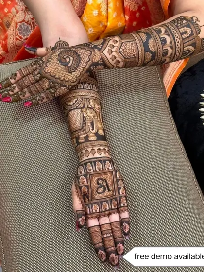 This Jaipuri bridal design includes a personalized initial 'S' on the palm, surrounded by elephant and swan motifs. It's a perfect blend of tradition and personal touch.