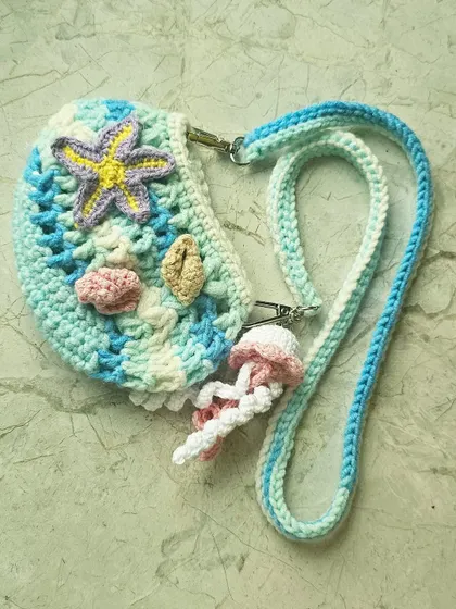 This is the mini crossbody version of my Ocean Bag, perfect for when you only need to carry the essentials. It has all the same beachy details, including a starfish and a detachable jellyfish charm.