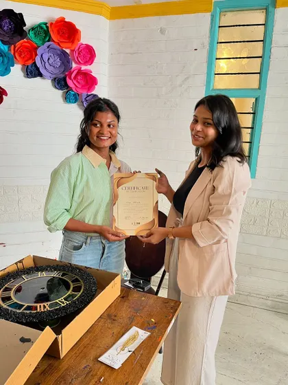A happy participant holding her certificate and the custom resin clock she made during our workshop.