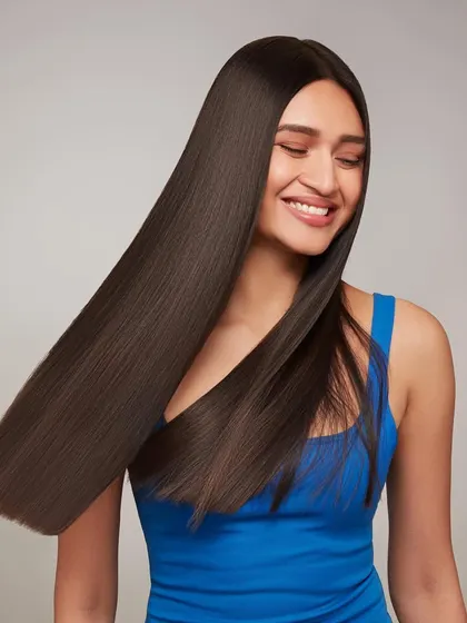 A shot for BBlunt capturing the movement and sleekness of straightened hair. The model's happy expression and the smooth swing of her hair convey a sense of satisfaction and confidence.