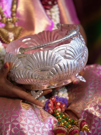Capturing the details of a traditional gift, a beautifully crafted silver bowl, being presented during a ceremony. These photos preserve the memory of blessings and gifts exchanged.