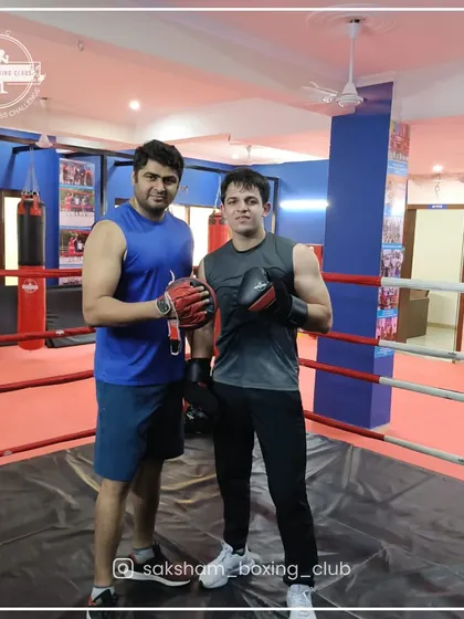 Our coaches are here to guide your fitness journey. Here, one of our expert trainers stands with a member in the ring, representing the personalized attention and professional mentorship you receive at our club.