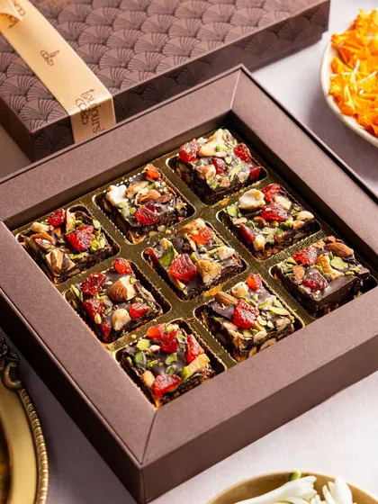 A box of rich, nutty date squares, a healthier yet indulgent option for festive gifting. Each square is packed with dates, nuts, and dried fruits, offering a burst of flavor and energy.