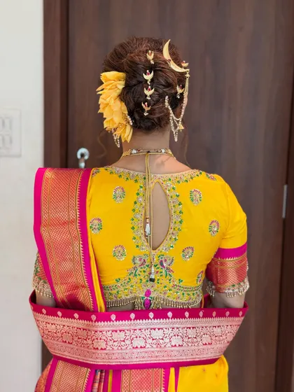 A detailed view of a traditional Marathi 'Khopa' hairstyle. I adorned this intricate bridal bun with a classic chandrakor accessory, ensuring the bride looks perfect from every angle.