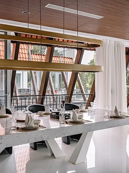 From this angle at Tellado Villas, you can see how the dining area overlooks the unique parabolic roof structure. The design intentionally blurs the lines between interior and exterior, making the architecture an integral part of the view.