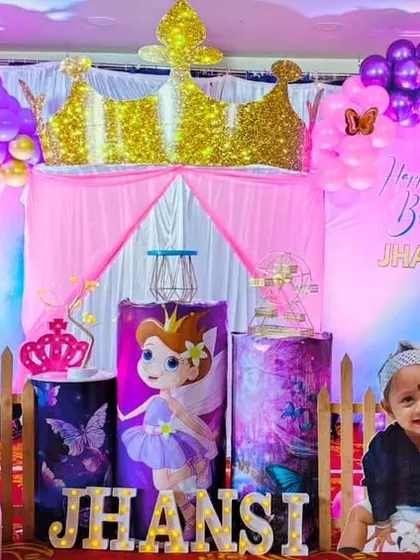 A royal celebration for a little princess. This fairy princess theme for Jhansi's first birthday includes a golden crown, character cutouts, and a pink and purple color palette.
