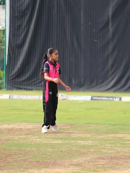 A young female fielder positions herself on the field during a U-10 game.