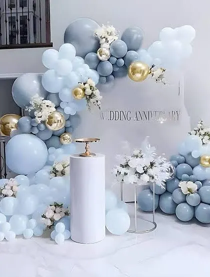 Celebrate your milestone with elegance. This sophisticated wedding anniversary decoration uses a soft blue, white, and gold color palette with a beautiful balloon arch and floral accents, creating a refined and memorable backdrop.