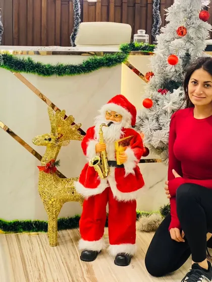 A member gets into the holiday spirit, posing with our festive Santa and reindeer decorations.