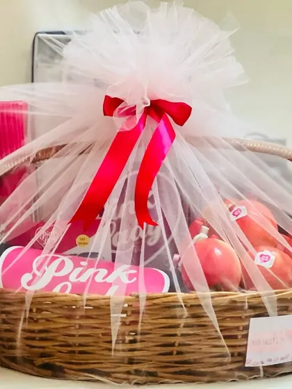 A beautifully wrapped 'Pink Lady' gift basket, showcasing the final presentation with white tulle and a bright pink ribbon.