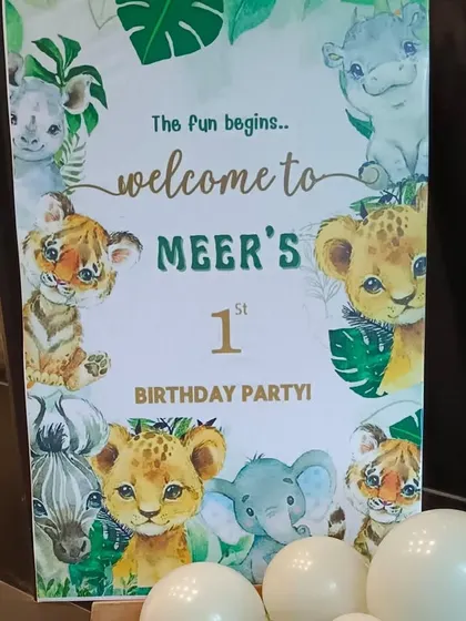 A welcome sign for Meer's first birthday party, featuring cute watercolor-style jungle animals.