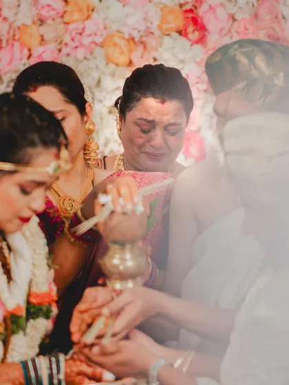 A hazy, dreamlike photo of an emotional ritual. The bride's makeup remains flawless, a crucial detail for wedding photography.