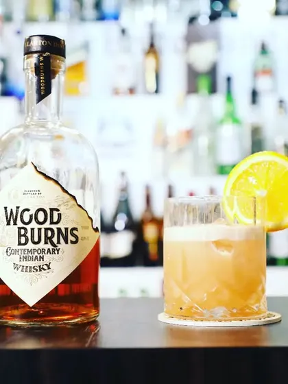A contemporary Indian whisky cocktail made with Woodburns, garnished with a lemon wheel. We are experts in using both local and international spirits.