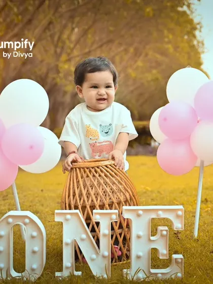 Celebrating one in the great outdoors. This setup combines a fun hot air balloon prop with the beauty of a sunlit park for a unique first birthday shoot.