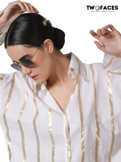An international model in a white and gold striped shirt with sunglasses, creating a chic and sophisticated look for a luxury fashion brand.