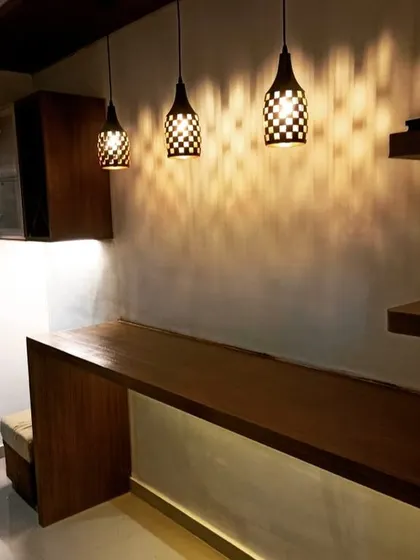The pendant lights create a beautiful pattern on the wall, adding to the ambiance of this small but stylish bar corner.