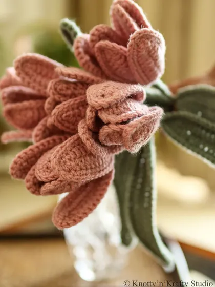 A detailed close-up of the dusty pink tulips, showing the delicate construction of the petals.