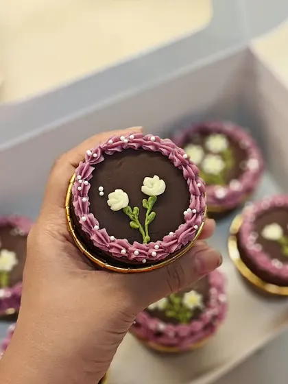 A close-up of another style of hand-piped flower on these chocolate cupcakes. Each one is slightly different and made with care.