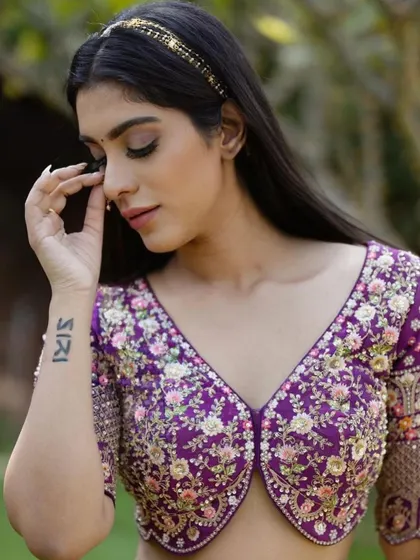 Royal in purple. This close-up shows the minimal yet impactful makeup, with a focus on a flawless base and softly defined eyes, letting the vibrant lehenga stand out.