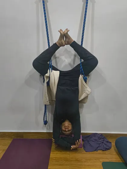 Sometimes it's a good idea to go upside down and clear your head. This student is in a supported headstand using the yoga wall, finding clarity and peace in the inversion.