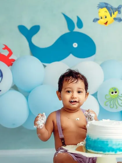 Hands full of cake and a happy heart. This under-the-sea theme is a popular choice for a vibrant and playful first birthday photoshoot.