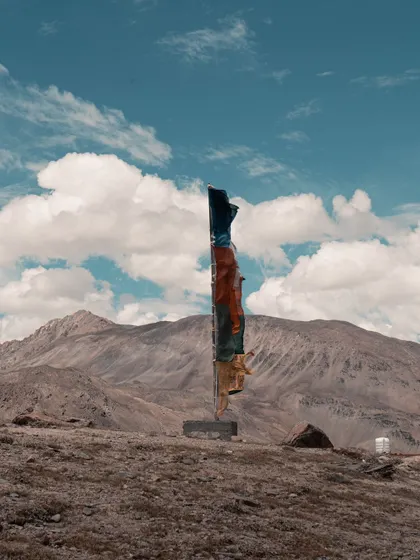 A lone line of prayer flags against the vast, empty landscape of Spiti. This simple composition evokes a sense of peace and spirituality.