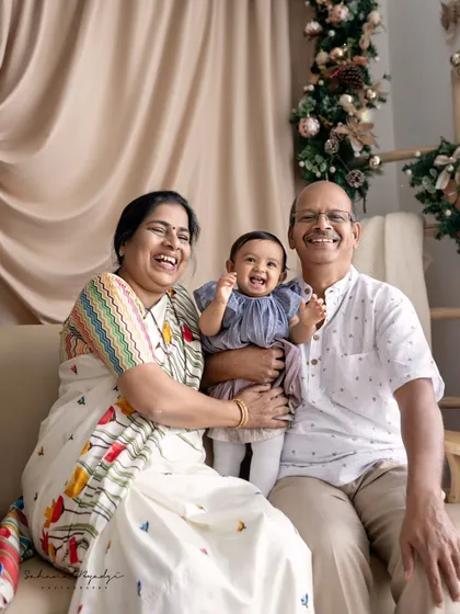 The whole family laughing together. The grandparents' joyful expressions as they interact with their granddaughter make this a truly heartwarming and precious memory.