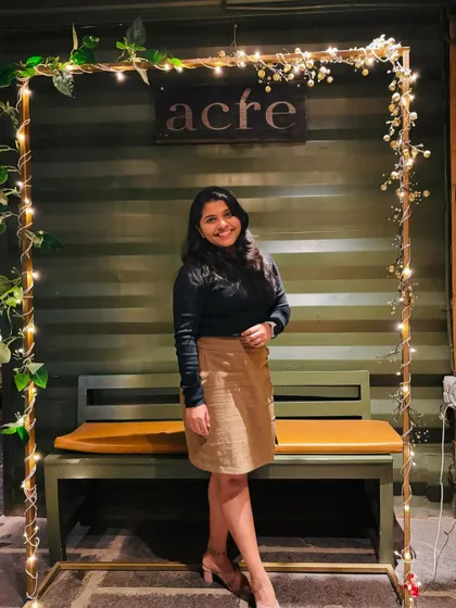 Posing with a pretty, lit-up frame at a cafe.