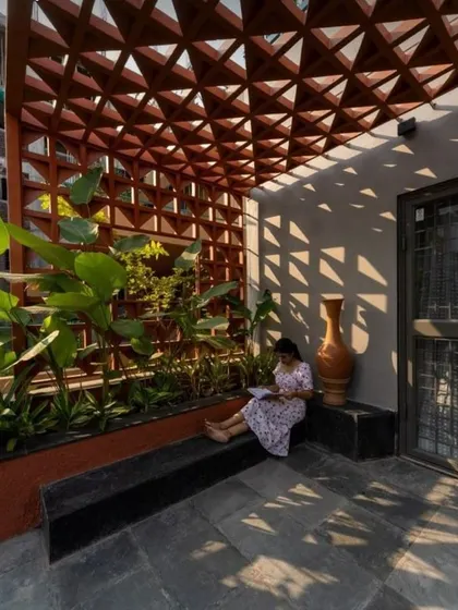We created this tranquil corner for a client who wanted a peaceful reading spot. The custom terracotta jali pergola casts beautiful shadows, creating a dynamic and serene atmosphere throughout the day, complemented by a built-in planter.