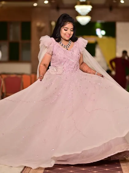 Twirling into her happily ever after. This light pink ball gown with its flowing skirt is perfect for capturing joyful, candid moments during an engagement celebration.