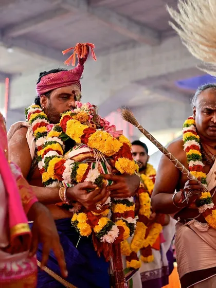 A priest carries a decorated kalash during a procession for the Rishi Homa. Every part of the ceremony, from preparation to conclusion, is conducted with reverence and joy.