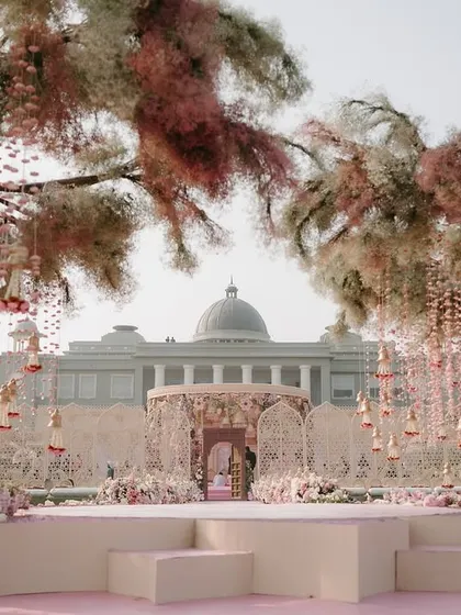 A stage view of the whimsical mandap, with its floral-covered trees and hanging kaleeras. This setup shows our ability to create a fantasy world for your special day.