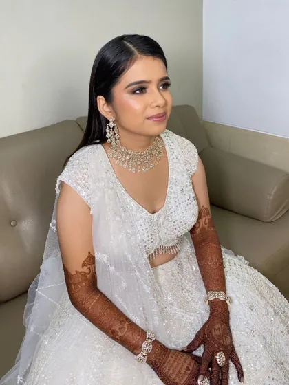 The complete look of sass and beauty. Her smokey eye makeup and radiant skin are the perfect match for her elegant, all-white sangeet ensemble.