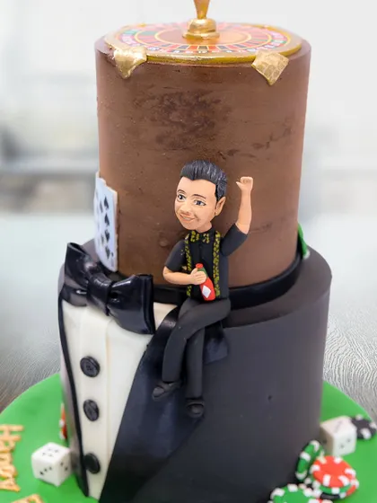 A detailed shot of the "Boss Cake," highlighting the handcrafted figurine and poker-themed elements.