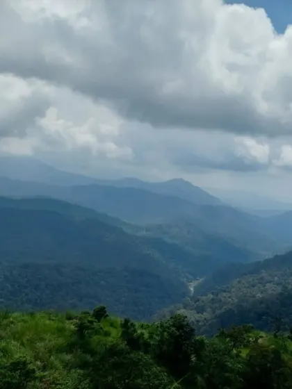 The layered hills of the Western Ghats as seen from Devaramane Betta, offering a breathtaking panoramic view.
