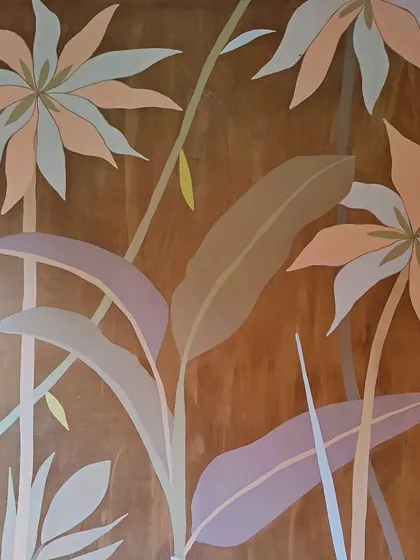 A close-up of the pastel-toned flowers against the rich brown wall.
